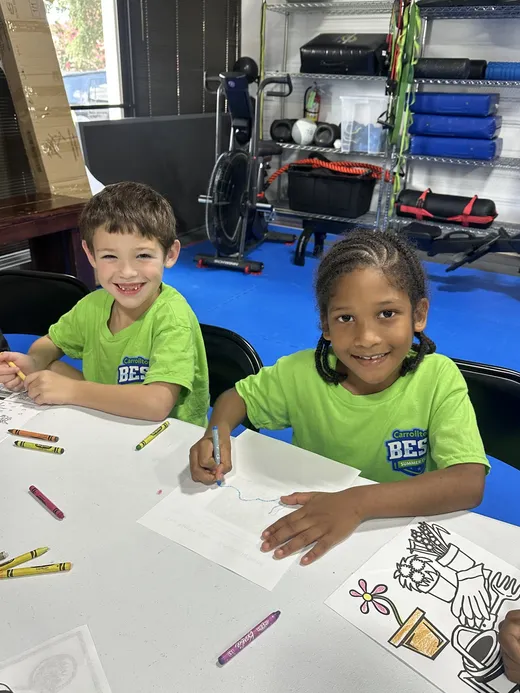 Two campers colouring at the craft table