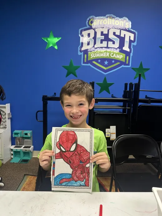 A camper holding up a finished drawing