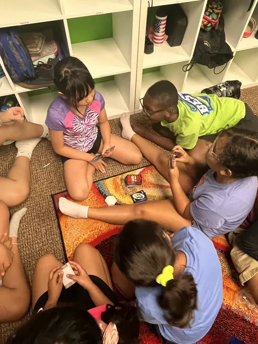 Campers playing a board game together on the floor