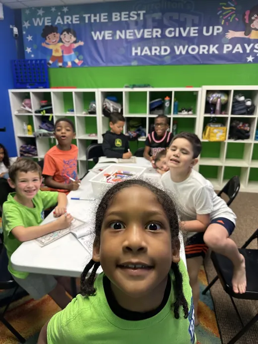 A camper grinning at the craft table