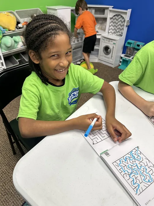 A camper concentrating on a puzzle worksheet