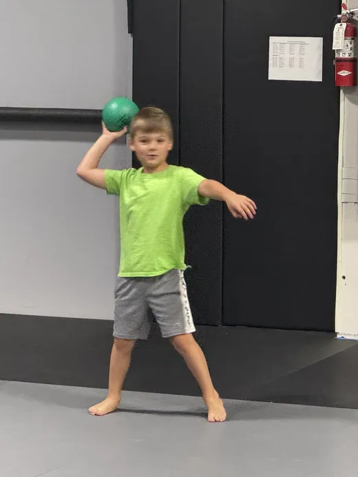 A camper throwing a ball during a team game