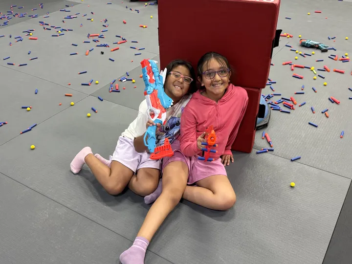 Two campers with water blasters on a water day