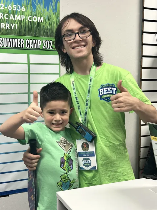 A coach with a camper giving a thumbs up